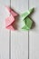 Paper origami handmade pink, green bunnies on white planks barn wood boards background
