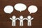 Paper people with colorful blank dialog speech bubbles on brown wood. Communication concept.