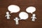 Paper people with colorful blank dialog speech bubbles on brown wood. Communication concept.