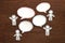 Paper people with colorful blank dialog speech bubbles on brown wood. Communication concept.