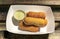 Paper plate with tequenos, Venezuela fried bread cheese sticks with queso blanco, from a food truck in Austin, Texas USA