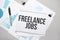 Paper plate with text freelance jobs. Diagram, notepad and blue background
