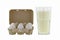 Paper pulp egg tray packages of fresh eggs next to glass of fresh pasteurized milk