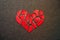 Paper red broken heart on dark felt background. Mosaic paper heart from pieces. Cracked heart symbol. Broken love concept.