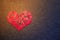 Paper red broken heart on dark felt background. Mosaic paper heart from pieces. Cracked heart symbol. Broken love concept. Copy s