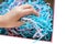 Paper shavings. Colored cut paper for packaging. Child`s hand examines