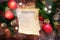 Paper sheet with text Christmas Dinner on rustic dark wood with burning red candles, fir branches, cinnamon stars and Christmas