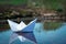 Paper ship in the water. paper boat origami sailing. beautiful background, unusual travel concept