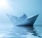 Paper ship in water and sunny blue sky