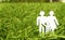 Paper silhouette of family in grass outdoors, space for text.