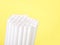 Paper straws clustered together on yellow background