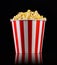 Paper striped bucket with popcorn on isolated black background