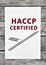 Paper with text HACCP certified on a wood  table