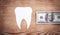 Paper tooth with money on wooden background