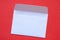 Paper white mail envelope lies on a red background close up