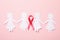 Paper women and awareness ribbon on pink background