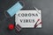 Paper with words CORONA VIRUS on stone background, flat lay