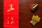 Paper wrote chinese text meaning of good wish beside plastic ancient chinese gold bar scene.