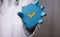 Papercut of a safety shield with a yellow checkmark in the hands of a doctor