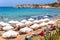 PAPHOS, CYPRUS - JULY 24, 2016: Tourists, sunbeds and umbrellas on hot summer day at Coral Bay Beach