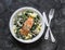 Pappardelle pasta with creamy spinach mushrooms sauce and baked salmon on a dark background, top view. Salmon florentine homemade