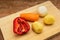 Paprika, potatoes, carrots and onions lie on a cutting board.