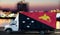 Papua New Guinea flag on the side of a white van against the backdrop of a blurred city and river. Logistics concept