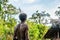 The Papuan from a Korowai tribe, live in the houses built on trees. On a background traditional Koroway house perched in a tree