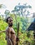 The Papuan from a Korowai tribe, live in the houses built on trees. On a background traditional Koroway house perched in a tree