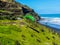 Para glider soars over the beach waves and hills at Murawai Beach Auckland New Zealand