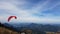 Para-gliders flying above multiple mountains