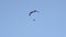 Parachute with motor flying on blue cloudy sky