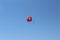 A parachute with a passenger painted in the colors of the Turkish flag for parasailing is high in the sky
