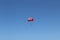 A parachute with a passenger painted in the colors of the Turkish flag for parasailing is high in the sky