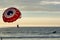 Parachute pushed by speedboat in the sea with sunset vacation