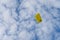 Parachuter descending with parachute against blue sky. Skydiver in the sky. People under parachute in the sky