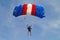 Parachuter, skydiver jumping and skydiving with blue red white colours parachute on parachuting cup, extreme sport