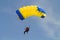 Parachuter, skydiver jumping and skydiving with blue yellow colours parachute on parachuting competition, extreme sport