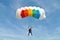 Parachuter, skydiver jumping and skydiving with colorful parachute in rainbow colours on parachuting cup, extreme sport