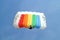 Parachuter, skydiver jumping and skydiving with colorful parachute in rainbow colours on parachuting cup, extreme sport