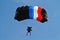 Parachuter, skydiver jumping and skydiving in parachute of black blue white red colours on parachuting cup, extreme sport