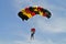 Parachuter, skydiver jumping and skydiving in parachute of black yellow red colours on parachuting cup, extreme sport