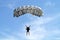 Parachuter, skydiver jumping and skydiving in parachute of grey color on parachuting competition, extreme sport