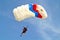 Parachuter, skydiver jumping and skydiving with parachute of white blue red colours on parachuting cup, extreme sport