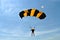 Parachuter, skydiver jumping and skydiving in parachute of yellow black colours on parachuting cup, extreme sport