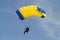 Parachuter, skydiver jumping and skydiving in parachute of yellow blue colours on parachuting competition, extreme sport