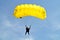 Parachuter, skydiver jumping and skydiving in parachute of yellow color on parachuting competition, extreme sport