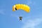 Parachuter, skydiver jumping and skydiving in parachute of yellow white black colours on parachuting cup, extreme sport