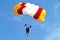 Parachuter, skydiver jumping and skydiving with yellow red white colours parachute on parachuting cup, extreme sport