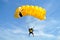 Parachuter, skydiver jumping and skydiving with yellow white black colours parachute on parachuting cup, extreme sport